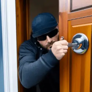 Intruder attempting to break into a house using lock bumping technique